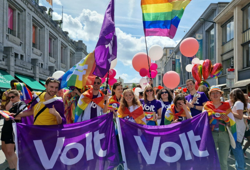 Volters wearing and holding rainbow flags and Volt flags at a Pride march