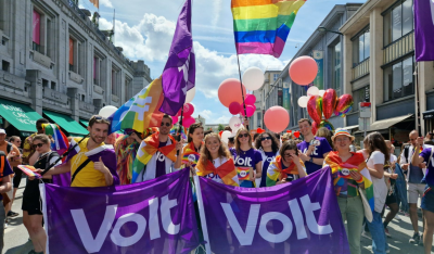 Volters wearing and holding rainbow flags and Volt flags at a Pride march
