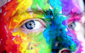 person, face painted in rainbow colours