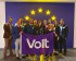 Group of Volters holding a Volt flag in front of European stars