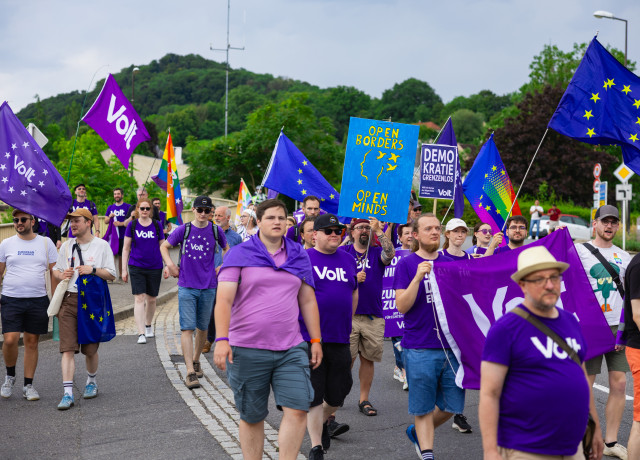 Lots of Volters marching with flags and banners