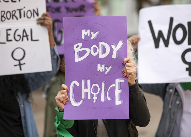 Women holding posters which read 