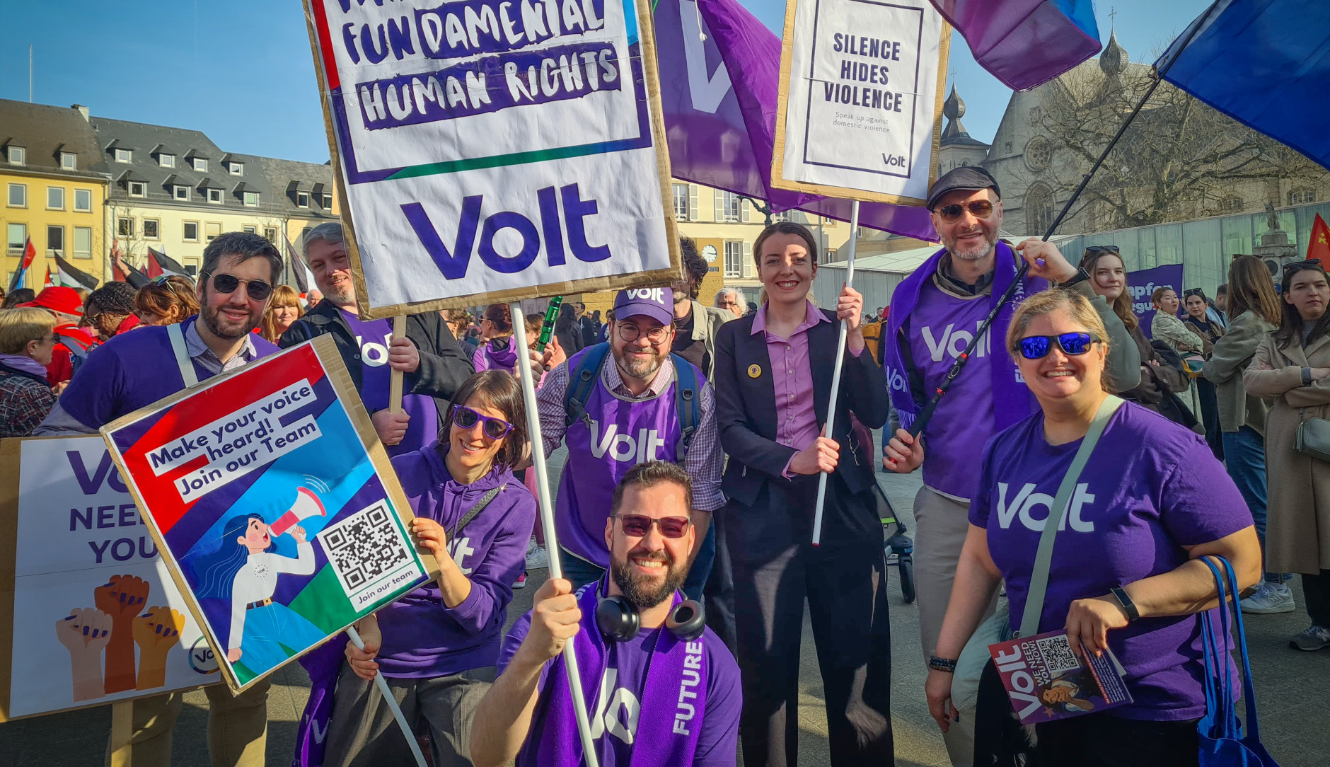 Volters holding flags and posters. One poster says 